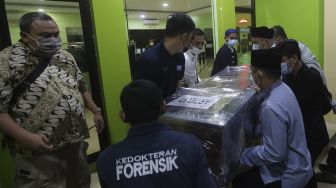 Keluarga dan kerabat membawa peti jenazah anggota Dewan Pengawas KPK Artidjo Alkostar untuk dishalatkan di Rumah Sakit Polri, Kramat Jati, Jakarta, Minggu (28/2/2021). [Suara.com/Angga Budhiyanto]