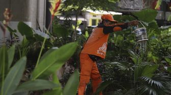 Petugas PPSU merawat tanaman di Taman Bibit Kelurahan Kebayoran Lama Utara, Jakarta, Minggu (28/2/2021). [Suara.com/Angga Budhiyanto]