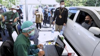 Menteri Kesehatan Budi Gunadi Sadikin (kiri) meninjau pelaksanaan vaksinasi COVID-19 dengan sistem 'drive thru' di Nusa Dua, Badung, Bali, Minggu (28/2/2021). [ANTARA FOTO/Fikri Yusuf]