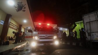 Mobil ambulans yang membawa jenazah anggota Dewan Pengawas KPK Artidjo Alkostar bersiap meninggalkan tempat persemayaman di Rumah Sakit Polri, Kramat Jati, Jakarta, Minggu (28/2/2021). [Suara.com/Angga Budhiyanto]