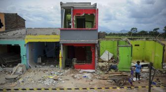 Warga terdampak proyek jalur kereta api ganda Kiaracondong-Cicalengka membawa puing yang masih bisa terpakai dari reruntuhan rumahnya di Panyileukan, Bandung, Jawa Barat, Minggu (28/2/2021). [ANTARA FOTO/Raisan Al Farisi]