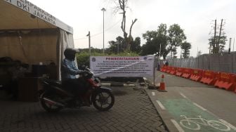 Pengendara sepeda motor keluar dari area pelataran parkir IRTI Monas, Jakarta, Selasa (2/3/2021). [Suara.com/Angga Budhiyanto]