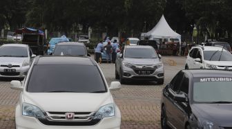 Supir taksi berbincang di pelataran parkir IRTI Monas, Jakarta, Selasa (2/3/2021). [Suara.com/Angga Budhiyanto]