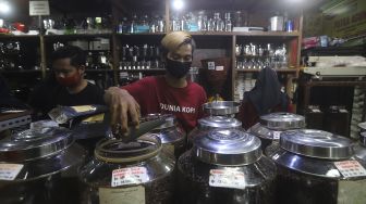 Pekerja menyortir biji kopi di salah satu gerai penjual biji kopi di Pasar Santa, Jakarta, Rabu (3/3/2021). [Suara.com/Angga Budhiyanto]