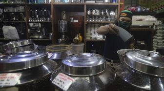 Pekerja menyortir biji kopi di salah satu gerai penjual biji kopi di Pasar Santa, Jakarta, Rabu (3/3/2021). [Suara.com/Angga Budhiyanto]