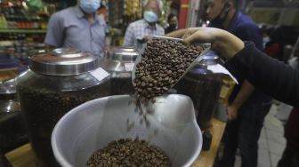 Pekerja menyortir biji kopi di salah satu gerai penjual biji kopi di Pasar Santa, Jakarta, Rabu (3/3/2021). [Suara.com/Angga Budhiyanto]