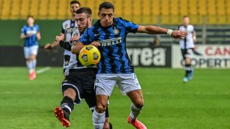 Pemain depan Inter Milan Alexis Sanchez (kanan) berduel memperebutkan bola dengan bek Parma Mattia Bani selama pertandingan sepak bola Serie A Italia Parma melawan Inter Milan di stadion Ennio-Tardini, Italia, Jumat (5/3/2021) dini hari WIB. MIGUEL MEDINA / AFP
.MIGUEL MEDINA / AFP