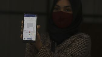 Petugas menunjukkan aplikasi di drop point rekosistem yang berada di Stasiun MRT Blok M, Jakarta, Jumat (5/3/2021). [Suara.com/Angga Budhiyanto]