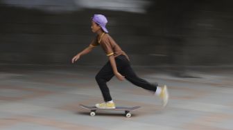 Seorang anak bermain papan luncur (skateboard) di trotoar kawasan Bundaran HI, Jakarta, Jumat (5/3/2021). [Suara.com/Angga Budhiyanto]