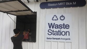 Warga membawa sampah anorganik untuk disetorkan di drop point rekosistem yang berada di Stasiun MRT Blok M, Jakarta, Jumat (5/3/2021). [Suara.com/Angga Budhiyanto]