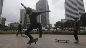 Sejumlah anak bermain papan luncur (skateboard) di trotoar kawasan Bundaran HI, Jakarta, Jumat (5/3/2021). [Suara.com/Angga Budhiyanto]