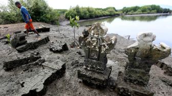 Nelayan melintas di kompleks situs sejarah makam Sundusu Balad yang terbengkalai dan tidak terawat di pesisir Pantai Gampong Pande, Banda Aceh, Aceh, Sabtu (6/3/2021). ANTARA FOTO/Irwansyah Putra