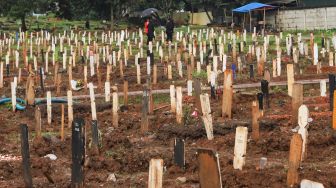 Suasana di area makam khusus Covid-19 di TPU Bambu Apus, Jakarta Timur, Sabtu (6/3/2021). [Suara.com/Alfian Winanto]