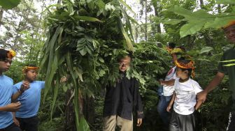 Anak-anak bertemu pencari rumput dalam pembelajaran Jelajah Rimba Sekolah Alam Kampung Baca Taman Rimba (Batara) di Papring, Kalipuro, Banyuwangi, Jawa Timur, Minggu (7/3/2021). [ANTARA FOTO/Budi Candra Setya]