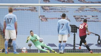 Gelandang Manchester United, Bruno Fernandes, melepaskan tembakan dari titik penalti untuk mencetak gol pertama timnya selama pertandingan sepak bola Liga Premier Inggris antara Manchester City melawan Manchester United di markas City, Etihad Stadium, Senin (8/3/2021) dini hari WIB.  PETER POWELL / POOL / AFP