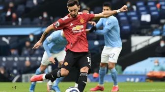 Gelandang Manchester United, Bruno Fernandes, melepaskan tembakan dari titik penalti untuk mencetak gol pertama timnya selama pertandingan sepak bola Liga Premier Inggris antara Manchester City melawan Manchester United di markas City, Etihad Stadium, Senin (8/3/2021) dini hari WIB.  PETER POWELL / POOL / AFP