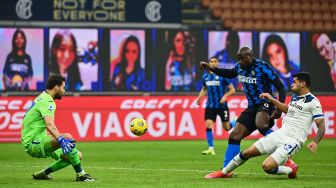 Penyerang Inter Milan Romelu Lukaku menembak melewati bek Atalanta Cristian Romero selama pertandingan sepak bola Serie A Italia Inter Milan melawan Atalanta di Giuseppe-Meazza, Selasa (9/3/2021) dini hari WIB. Miguel MEDINA / AFP
