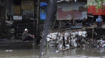 Seorang warga mengoperasikan perahu eretan untuk menyeberangi Kali Ciliwung di kawasan Manggarai, Jakarta, Selasa (9/3/2021). [Suara.com/Angga Budhiyanto]