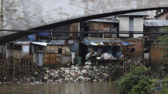 Seorang warga beraktivitas di permukiman bantaran Kali Ciliwung, kawasan Manggarai, Jakarta, Selasa (9/3/2021). [Suara.com/Angga Budhiyanto]