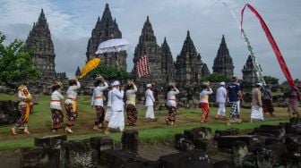 Umat Hindu berjalan menuju candi saat upacara Tawur Agung Kesanga di Candi Prambanan, Sleman, DI Yogyakarta, Sabtu (13/3/2021). ANTARA FOTO/Hendra Nurdiyansyah
