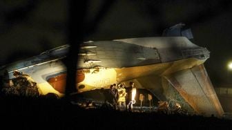 Penyelidik bekerja di lokasi jatuhnya pesawat Antonov An-26 di Bandara Almaty, Kazakhstan, pada (13/3/2021). [Abduaziz MADYAROV / AFP]