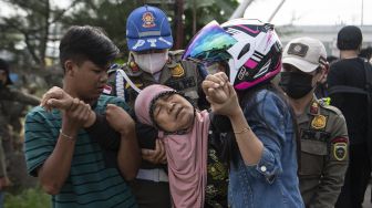 Anggota Sat Pol PP Provinsi Sumatera Selatan mengevakuasi warga saat penertiban bangunan liar di Jln Gub Hasan Bastari Jakabaring, Palembang, Senin (15/3/2021). [ANTARA FOTO/Nova Wahyudi]