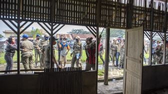 Sejumlah Anggota Sat Pol PP Provinsi Sumatera Selatan membongkar bangunan liar yang berada di Jln Gub Hasan Bastari Jakabaring, Palembang, Senin (15/3/2021). [ANTARA FOTO/Nova Wahyudi]