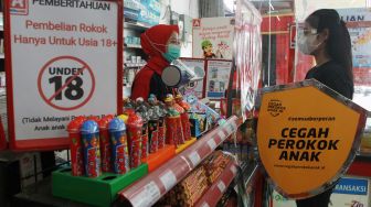 Seorang relawan melakukan edukasi tentang bahaya merokok kepada kasir sebuah mini market saat kampanye "Cegah Perokok Anak" di Peta Barat Cengkareng, Jakarta, Rabu (17/3/2021). ANTARA FOTO/Muhammad Iqbal