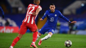 Gelandang Chelsea Hakim Ziyech bersaing dengan bek Atletico Madrid Renan Lodi selama selama pertandingan leg kedua babak 16 besar Liga Champions antara Chelsea melawan Atletico Madrid di Stamford Bridge, Kamis (18/3/2021) dini hari WIB. Ben STANSALL / AFP
