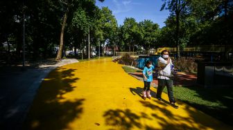 Seorang bapak mendampingi anaknya bermain sepatu roda di Taman Puring, Jakarta, Minggu (21/3/2021). ANTARA FOTO/Rivan Awal Lingga