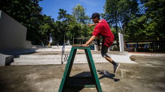 Seorang warga melompati rintangan saat berolahraga di Taman Puring, Jakarta, Minggu (21/3/2021). ANTARA FOTO/Rivan Awal Lingga
