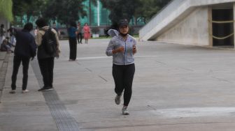 Warga berolahraga sore di Taman Lapangan Banteng, Jakarta Pusat, Minggu (21/3/2021). [Suara.com/Alfian Winanto]