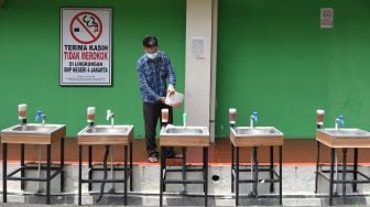 Karyawan mengisi ulang sabun cair di wastafel Sekolah Menengah Pertama (SMP) Negeri 4, Jakarta Pusat, Senin (22/3/2021).  ANTARA FOTO/M Risyal Hidayat
