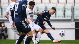 Penyerang Juventus Cristiano Ronaldo (kanan) menendang bola selama pertandingan sepak bola Serie A Italia Juventus melawan Benevento di Juventus Stadium, Turin, Minggu (21/3/2021) malam WIB. Marco BERTORELLO / AFP