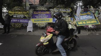 Pekerja mengantarkan karangan bunga tanda berduka cita atas meninggalnya Mantan Jaksa Agung Basrief Arief ke rumah duka di kawasan Petogogan, Kebayoran Baru, Jakarta, Selasa (23/3/2021). [Suara.com/Angga Budhiyanto]