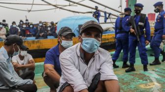 Anggota Korps Kepolisian Perairan dan Udara (Korpolairud) Baharkam Polri mengamankan sejumlah ABK kapal nelayan berbendera Vietnam di Pelabuhan Batu Ampar Batam, Kepulauan Riau, Rabu (24/3/2021). ANTARA FOTO/Teguh Prihatna