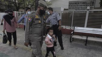 Petugas Suku Dinas Sosial dan Satpol PP Jakarta Selatan membawa warga yang terjaring razia Penyandang Masalah Kesejahteraan Sosial (PMKS) di kawasan Bulungan, Jakarta , Rabu (24/3/2021). [Suara.com/Angga Budhiyanto]