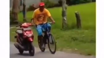 Ngakak Abis! Bapak Ini Dorong Motor Sambil Mengayuh Sepeda