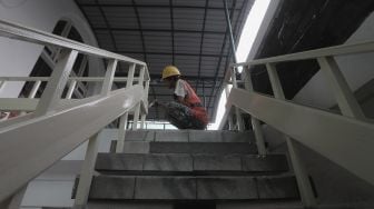 Pekerja menyelesaikan perbaikan Masjid Cut Meutia, Jakarta, Kamis (25/3/2021). [Suara.com/Angga Budhiyanto]