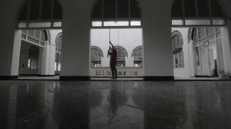 Pekerja menyelesaikan perbaikan Masjid Cut Meutia, Jakarta, Kamis (25/3/2021). [Suara.com/Angga Budhiyanto]