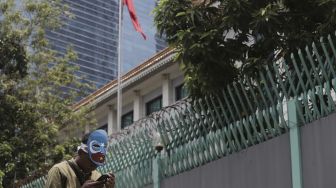 Seorang massa yang tergabung dalam Aliansi Mahasiswa Islam (AMI) beristirahat di sela-sela melakukan aksi unjuk rasa di depan Kedutaan Besar Republik Rakyat China, Kuningan, Jakarta, Kamis (25/3/2021). [Suara.com/Angga Budhiyanto]