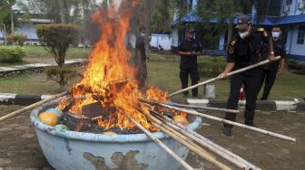 Petugas membakar tumpukan jaring dan peralatan kapal pencuri ikan saat giat pemusnahan di Stasiun PSDKP Pontianak, Kabupaten Kubu Raya, Kalimantan Barat, Kamis (25/3/2021). [ANTARA FOTO/Jessica Helena Wuysang]