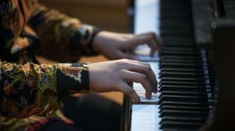 Pianis Jefri Setiawan (15) tampil dengan mata tertutup kain dalam konser pemecahan rekor di Universitas Yarsi, Jakarta, Rabu (24/3/2021). ANTARA FOTO/Aditya Pradana Putra