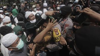 Massa pendukung Rizieq Shihab melakukan demonstrasi saat berlangsungnya sidang lanjutan kasus pelanggaran protokol kesehatan dengan terdakwa Rizieq Shihab di depan Pengadilan Negeri (PN) Jakarta Timur, Jakarta, Jumat (26/3/2021). [Suara.com/Angga Budhiyanto]