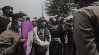 Massa pendukung Rizieq Shihab melakukan demonstrasi saat berlangsungnya sidang lanjutan kasus pelanggaran protokol kesehatan dengan terdakwa Rizieq Shihab di depan Pengadilan Negeri (PN) Jakarta Timur, Jakarta, Jumat (26/3/2021). [Suara.com/Angga Budhiyanto]