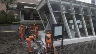 Petugas gabungan Unit Kerja Perangkat Daerah (UKPD) membersihkan trotoar sepanjang Jalan Sudirman-Thamrin, Jakarta, Sabtu (27/3/2021). [Suara.com/Angga Budhiyanto]