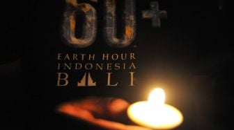 Warga menyalakan lilin membentuk angka 60 plus saat peringatan Earth Hour di Denpasar, Bali, Sabtu (27/3/2021).  ANTARA FOTO/Fikri Yusuf
