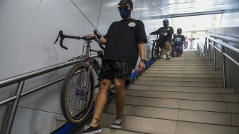 Penumpang membawa sepeda non-lipat di Stasiun MRT Bunderan HI, Jakarta, Minggu (28/3/2021). ANTARA FOTO/Galih Pradipta