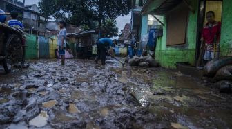 Warga membersihkan sisa lumpur pascabanjir luapan sungai di kawasan Sukamiskin, Bandung, Jawa Barat, Sabtu (27/3/2021).  ANTARA FOTO/Novrian Arbi
