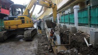 Pekerja menyelesaikan penataan kawasan Stasiun Gondangdia di Jakarta, Senin (29/3).  [Suara.com/Dian Latifah]